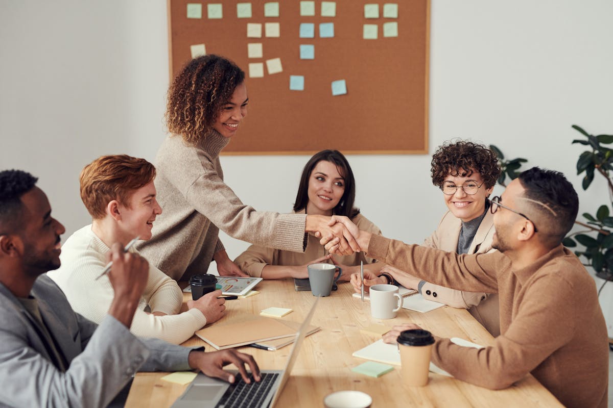 Diverse team of professionals collaborating around a conference table with laptops and documents
